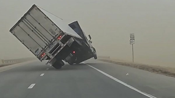 High winds knock truck onto its side as it travels down highway