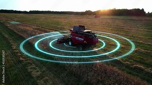 Self-driving autonomous harvester scans farm field during harvesting. Hybrid electric combine with hud elements, aerial view, motion graphics elements. Future technology with smart agriculture farming