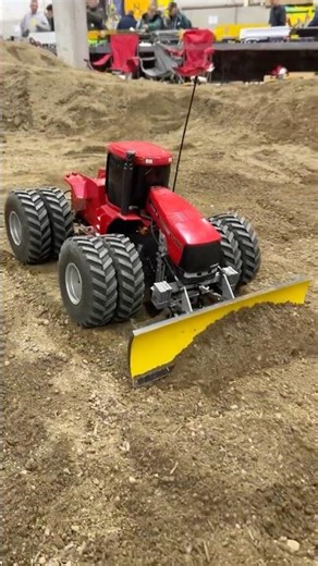 RC tractor with a blade pushing dirt