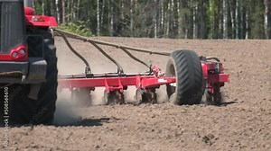 Farm tractor planting corn in a field. tractor planting crops on an agricultural field. tractor working in the field, harvesting, business, agriculture. soil preparation, spring season
