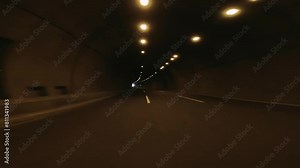 Car navigates through dark road tunnel on highway, showcasing highway driving. Video highlights experience from highway perspective, emphasizing highway travel dynamics