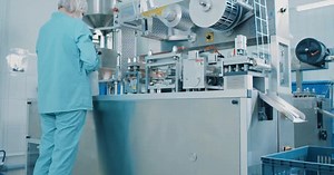 Factory Worker tending Automated Packaging Machine