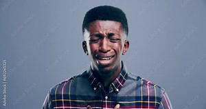 Man, grief and crying face for sad with shock, mental health and anxiety by gray background. African person, portrait and pain with trauma stress with broken heart, mistake or loss in studio mockup
