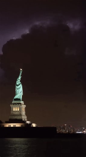 Nature putting on a spectacular light show over New York Harbor tonight. 🗽⚡️ The contrast is incredible: the chaotic, rolling purple storm clouds clashing with the steady, illuminated calm of Lady Liberty. 🌩️🏙️It’s rare to see the sky so alive with electricity while the city’s most famous icon stands completely still. | Ethereal Earth
