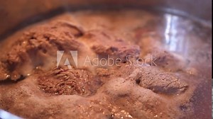 Beef casserole cooking. Foam coming from boiling beef in a casserole. Traditional recipe. Close up slow motion shot.