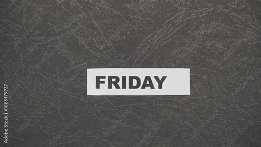 Crumpled paper strip unfolds on a black background, revealing weekday names from Monday to Sunday. Stop motion