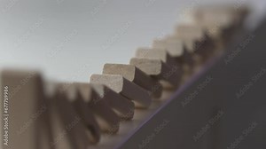 falling line of wooden domino blocks each knocking the next over, domino effect slow motion