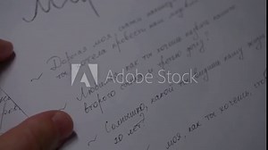 Closeup hand written text on paper, pen, hand in letter. Against the background of the yellow table, in the evening in the apartment, the house, the room