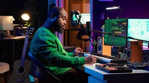 Songwriter taking notes to create new tracks for an album in his home studio, writing lyrics and harmonic elements before recording his song and editing on software, acoustical engineering. Camera A.