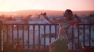 Extreme closeup of belly dancers chest as she performs a chest shimmy at sunset on a rooftop in Morocco.