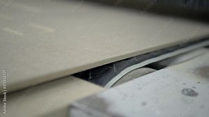 The wooden product comes out of the woodworking machine on the tape. Grinding process