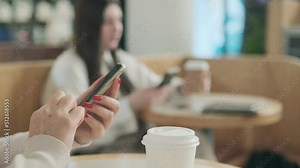 Alternative macro close up of an young businesswoman hands busy working on smartphone for send emails and surf on a web browser.