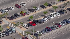 Top view busy parking lot with many cars moving in and out timelapse.
