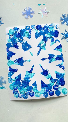 Mandisa | Happy Toddler Playtime on Instagram: "Comment “SNOWFLAKE” for free snowflake templates. Did you know you can create stunning negative space snowflakes using corks and paint? ❄️✨ Place a snowflake stencil or cut-out on paper, then use a cork dipped in paint to stamp around it. Remove the stencil to reveal a beautiful snowflake design in the negative space. It’s a fun and creative winter craft for kids! #SnowflakeCraft #CorkPainting #WinterArt #CreativeKids"