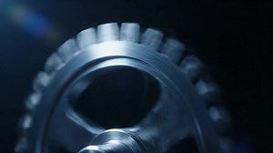 Up Close View of a Single Silver Cogwheel Against a Dark Background