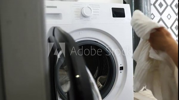 Housewife using a washing machine, loading clothes into the machine. Stock Video