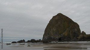 Haystack Rock beach in coastal town Cannon Beach, Oregon. Cloudy day