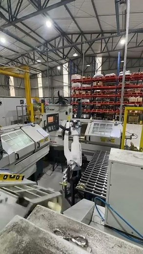Robô articulado manipulando peças em tornos CNC