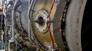 An engineer is servicing an aircraft engine. Jet engine nozzle. Fuel line. Jet engine repair. Maintenance of the turbojet engine. Close-up.