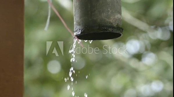 Rainwater pouring out of rain gutter from roof, raindrops out of PVC pipe