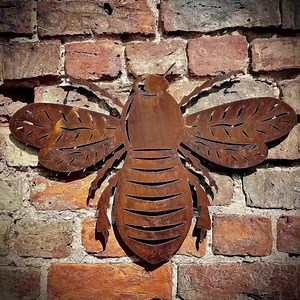 Rusty Metal Bee Home & Garden Decoration. Can be used inside or outside. Our Bee's are made from a high grade 2mm thick steel, which we then put through a rusting process to give them an aged patina. The mounting - Simply drill straight through the metal and attach with a screw or fix using a good strong adhesive, or can be hung on a hook. Dimensions are approximately; Height 36cms Width 51cms #bee #beeart #beedecor #beelover #homeandgarden #gardendecor #gardeninspiration #wallart #gift #giftide