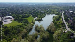 Drone flying over Markham park with a pond on it on a summer day.