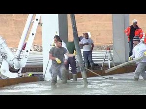 Booted workers in knee-deep cement