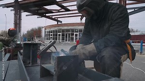 Welding of metal structures. Worker welds metal structural elements, welding machine. 60fps. Close-up.