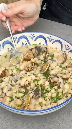 Alubias con almejas 🫘Un plato de cuchara sutil y con un sabor increíble, porque no siempre vamos a acompañar a las judías o habichuelas con chorizo 😅▪️Ingredientes:300 g de alubias o judías blancas secas400 g de almejas2 cebollas4 ajos1 hoja de laurel8-10 hebras de azafrán1 cucharada de harina de trigo100 ml de vino blanco200 ml de aguaPerejil fresco picadoAceite de oliva virgen extraSal▫️En una olla echamos las alubias remojadas la noche anterior con una cebolla cortada en 4 trozos, 2 dientes