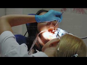 Dentist doing a dental treatment on a female patient.