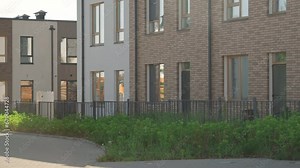 Establishing shot of two-storey buildings with brown brick wall elements in suburban area on sunny day