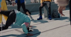man breakdancing on rooftop at hip hop dance party performing crazy breakdance moves with friends dancing and celebrating