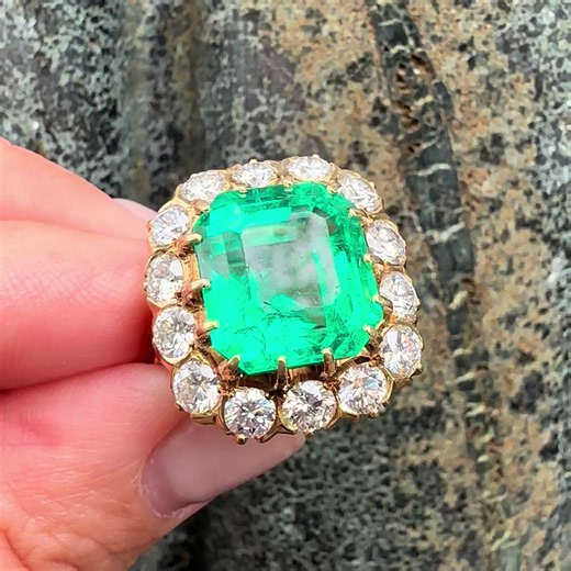 VERY FINE 11.5CT COLOMBIAN EMERALD & DIAMOND HALO COCKTAIL RING 💚 A true statement of presence and pedigree. This exceptional vintage ring centers a massive AGL-certified Colombian emerald, weighing approximately 11.5 carats, showcasing that coveted rich, vibrant “happy” green color with impressive life and transparency. Framed by a bold halo of 2.80 carats of brilliant-cut diamonds (F/G color, VS clarity), the contrast is striking—bright white fire against deep Colombian green. Set in solid 18