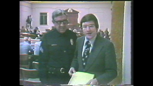 In 1975, former WLAC-TV reporter Don Dare is whisked away after ignoring a Metro Police officer’s request to leave the room. Long-time anchor Chris Clark reacts in good humor. WLAC-TV became WTVF later that year. | NewsChannel 5 Nashville