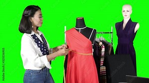 Female tailor measuring and fitting a dress