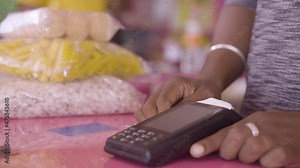 Close up shot of hand paying money by taping mobile phone to swiping machine at retail Kirana or Groceries store - concept of contectless and one tap digital payment