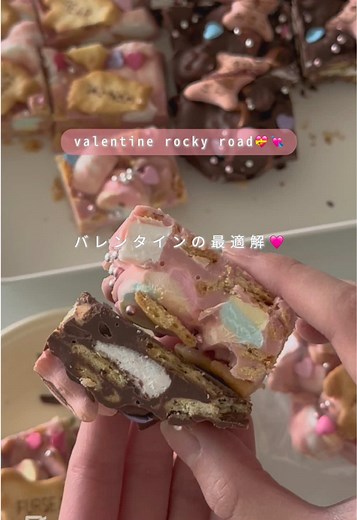 💘recipe オーブン不要、テンパリングもいらない簡単レシピ😇いろんな食感で楽しいロッキーロードを作りました🍫ミルクチョコやブラックチョコの場合はナッツを入れても美味しいです🤤 動画的に最適解という書き方をしてるけどあなたが選んだものがあなたにとっては最適解だと思います😌綺麗事じゃなくてねマインドが大事です💘と思っています🐥 材料 ・板チョコ3枚分(ピンク、ホワイトチョコレートは135g、ミルク・ブラックは150g) ・無塩バター15g ・マシュマロ40g ・ビスケット34g(たべっこどうぶつ2袋) ・お好みのトッピング ①マシュマロは小さくカットし、ビスケットは粗く砕いておく ②ボウルに砕いたチョコレートとバターを入れ、60度くらいの湯煎で溶かす ③湯煎を外してマシュマロとビスケットをくわえる ④混ざったらクッキングシートを敷いたバットに流して形を整える ⑤お好みでトッピングをする ⑥冷蔵庫で2時間〜冷やし固める ⑦お好みの大きさにカットしてできあがり🫶🏻 ポイント💝 ・湯煎のお湯は熱湯じゃなくて50-60度くらい ・湯煎の時にお湯がチョコレートに入らないように