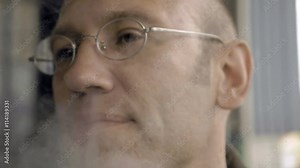 A man is exhaling the smoke from his nostrils. E-cigarettes are the new sensation of smoking culture. Vapor does not need flame to start it. 4K UHD video footage. Stock Video