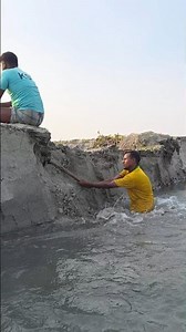 The man was sitting on the river bank.