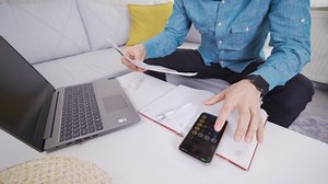 Calculate the invoice. Using a calculator. Man makes calculations with calculator at home.