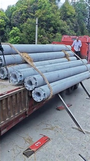 Unloading a giant cement power pole.