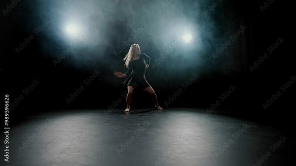 Contemporary dance performance, blonde woman dancing in darkness, slow motion. Beautiful slender woman dancing alone on stage, hobby and passion, graceful female figure in dark, performing dance show