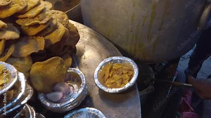 Close-up of Mathri Aloo, classic savory Indian snack or crackers. A flaky biscuit made from flour, water, and cumin seeds served with potato masala curry. slow motion Handheld stabilized gimbal 4k