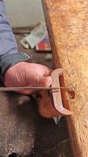 Filing metal piece steadily with hand file in wooden clamp