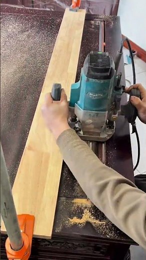 Routing precise straight grooves into a wooden table surface using a powerful electric hand router