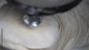Kneading dough using a kitchen machine. Making yeast-free bread with the table stand mixer. Kitchen aid kneads flour to make dough, close up