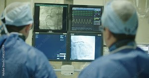 Surgeons watching monitors with x-ray images during a Cardiac catheterization procedure Stock Video