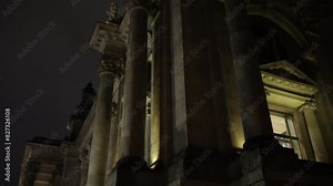 German flags, Berlin landmark, Germany night. Historic Reichstag Building stands out at night, illuminated and decorated with flags.