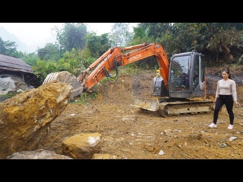 Excavator leveling the ground for building a new house - Girl leading excavator working