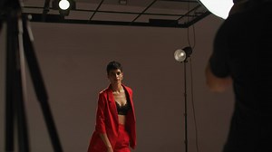 Model poses as camera lights flash in a studio - Free Stock Video